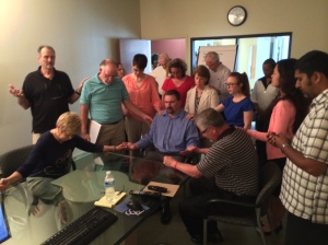 ICM staff and prayer team praying for Andy before he begins the month long trip.